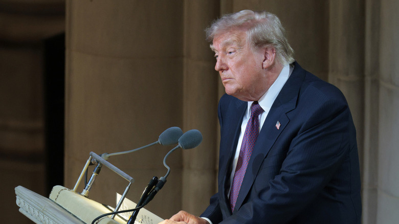 Donald Trump standing at a podium with two microphones