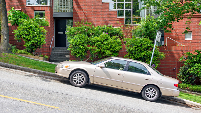 A car parked on a steep incline in a residential neighbourhood.