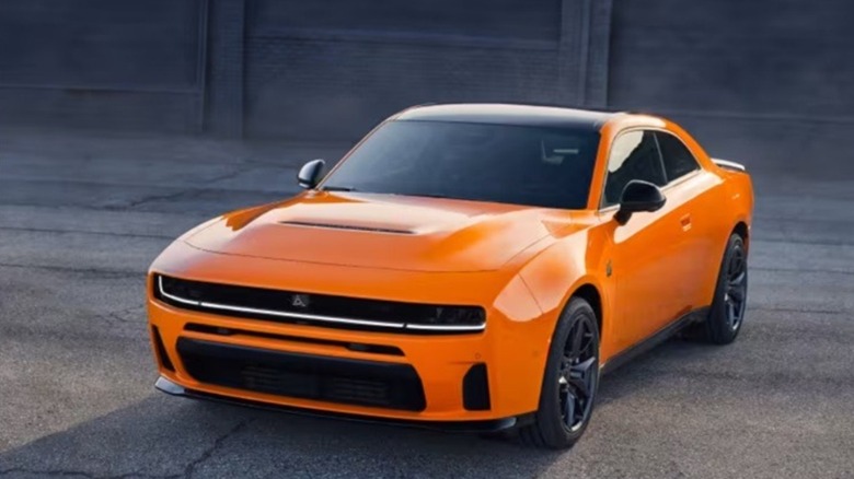 Orange 2026 Dodge Charger on an asphalt surface in front of a building