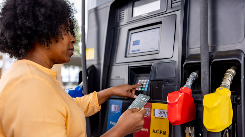 A person paying for gas with a credit card at a gas station.