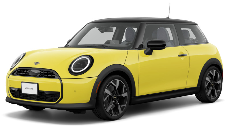 Front three-quarters shot of a yellow Mini Cooper C Oxford Edition in front of an all-white background