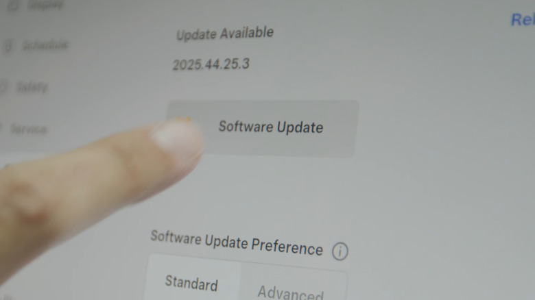 Close-up of driver selecting to update software on Tesla screen